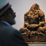 Afghan visitors look at a Buddha statue, ©AFP/Getty Images